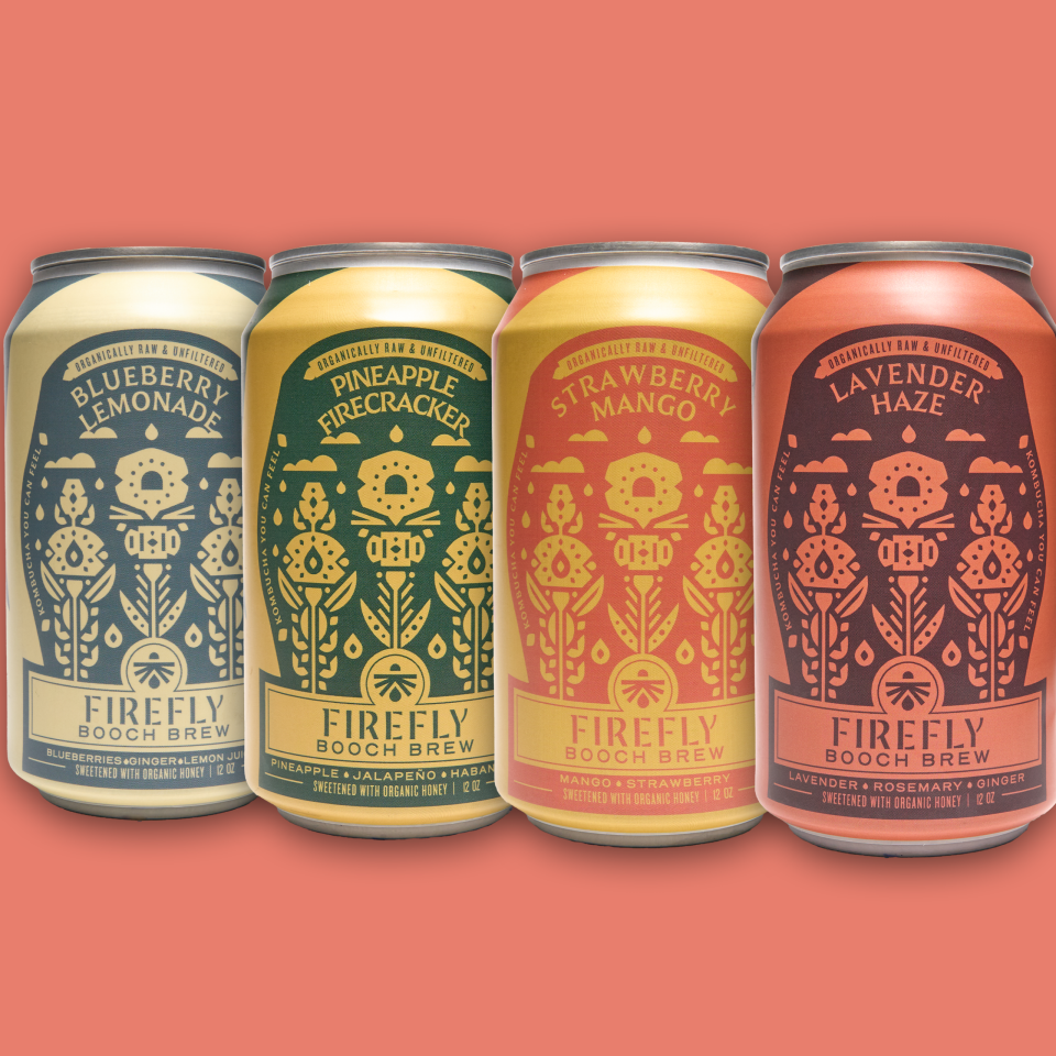 Four Firefly Brew kombucha cans with colorful labels on a pink background.